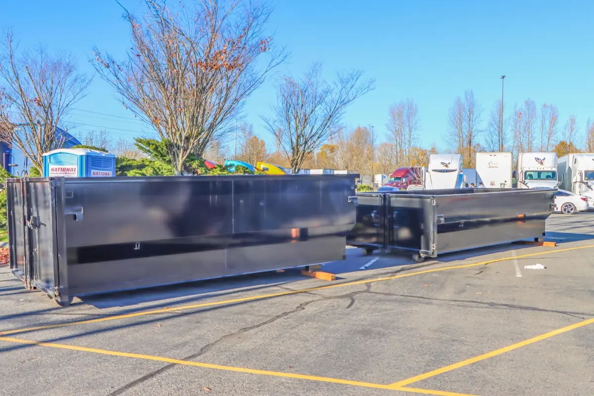 Professional dumpster rental service with roll-off container on residential driveway in Bradford